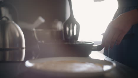 woman-is-cooking-homemade-food-frying-pancakes-in-sunday-morning-closeup-of-stove-with-frying-pan